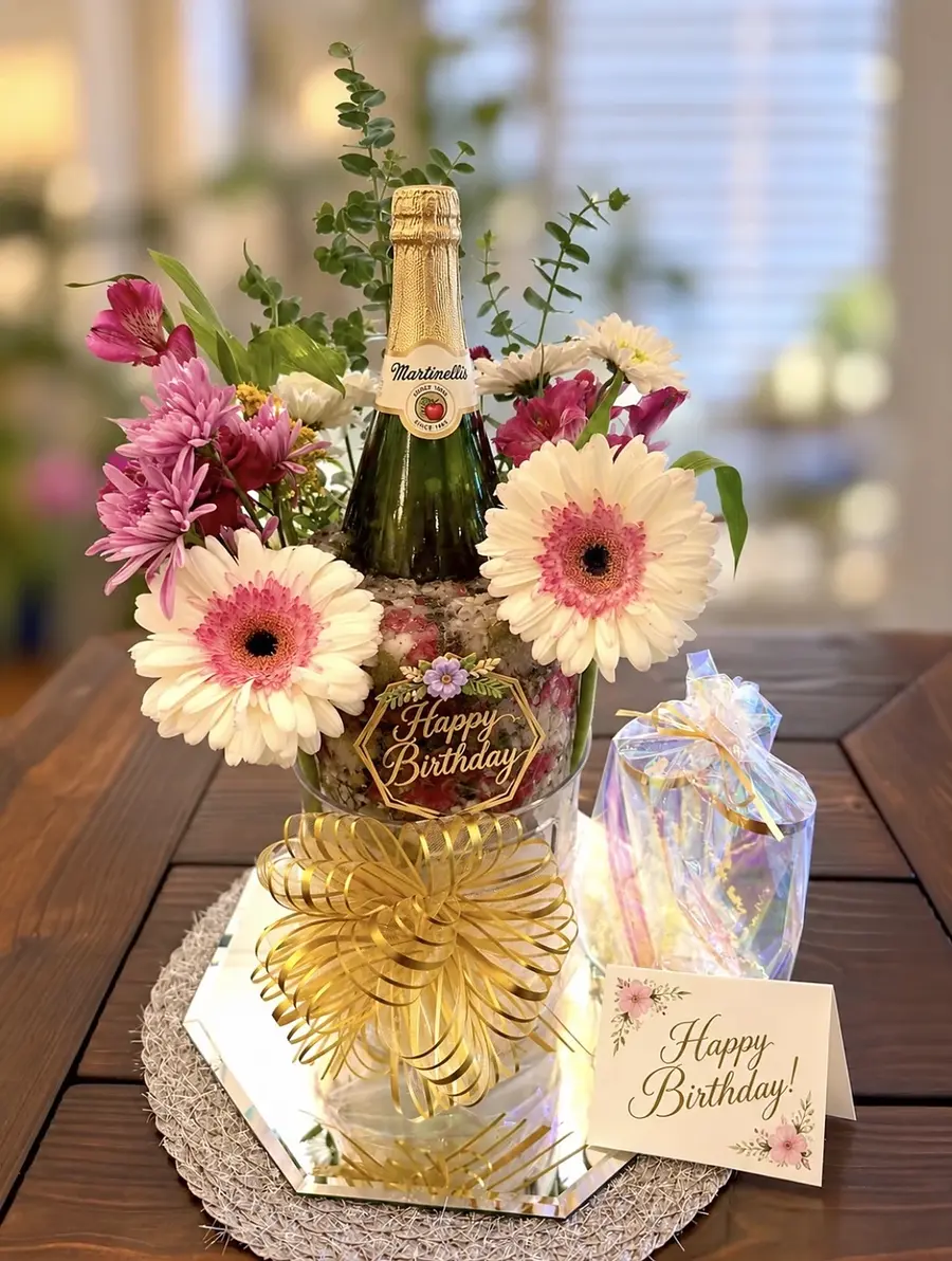 Complete Celebration Bloom gift with sparkling cider, flower-filled ice, coordinating fresh flowers, gold bow, personalized card and wrapped flutes