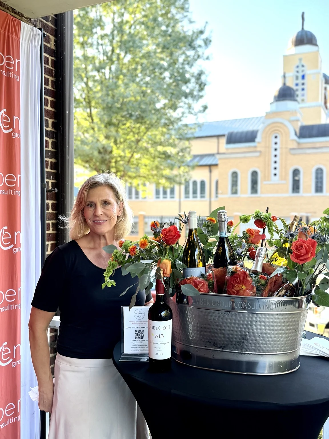 The creator of Blooms on Ice beside a floral ice display at an Ember Group celebration